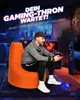 A man is playing video games while sitting on an orange beanbag chair in a dimly lit room. Produktbild-Vorschau