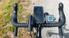 A close-up view of a bicycle's handlebars with various accessories attached. Produktbild-Vorschau