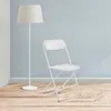 A white folding chair and a white floor lamp are shown in a room with light blue tiled walls and a wooden floor. Anteprima dell’immagine prodotto