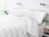 A neatly made bed with white bedding. Náhled obrázku produktu