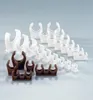 A collection of plastic pipe clips in white and brown, arranged in rows on a light gray background. Náhľad obrázku produktu
