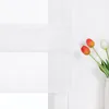 A white sheer roman blind with a bouquet of tulips in a vase on the right side. Produktbild-Vorschau