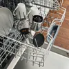 Dishwasher rack with mugs, plates, and coffee grinder parts. Náhled obrázku produktu