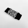 A single dog knee brace with a black and white striped pattern is lying on a white background. Produktbild-Vorschau
