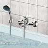 A bathroom faucet and showerhead are shown mounted on a tiled wall above a bathtub filled with water. Produktbild-Vorschau