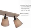 A close-up view of a beige ceiling lamp with two adjustable fabric shades, with descriptive text in German and English on the right side. Produktbild-Vorschau