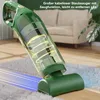 A green cordless vacuum cleaner is shown on a rug and wooden floor, with a sofa and plant in the background. Produktbild-Vorschau