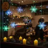 Christmas lights in the shape of snowflakes and LED candles are displayed on a windowsill in front of a coffee shop. Produktbild-Vorschau
