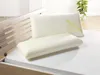 Two pillows are placed on a bed, with a wooden bed frame visible on the left and a plant in the background. Produktbild-Vorschau
