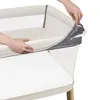 Hands are shown adjusting a zipper on a baby bassinet. Produktbild-Vorschau