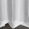 A close-up view of white sheer curtains with a textured pattern, draped over a dark floor. Produktbild-Vorschau