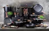 A collection of cookware and kitchen utensils displayed on a surface with a textured gray background. Anteprima dell’immagine prodotto