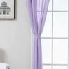 A close-up of a purple curtain tied back with a fabric band, hanging in front of a window with white mullions. Produktbild-Vorschau