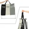 A collage showing a three-compartment laundry basket organizer. One image shows the full basket with labels for dark, light, and color laundry. Another image shows a hand holding the handles of the folded basket. Produktbild-Vorschau