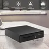 A black cash drawer is placed on a wooden desk, with a laptop in the background. Podgląd zdjęcia produktu