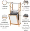 A bamboo and white laundry shelf unit with a fold-out laundry collector and informational callouts. Produktbild-Vorschau