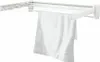 A white towel is hanging on a white wall-mounted drying rack. Produktbild-Vorschau