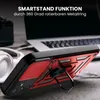 A red and black phone case with a ring stand is shown on a desk next to a laptop and headphones. Produktbild-Vorschau