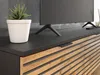 A close-up view of a modern TV stand with a plant and a television. Náhled obrázku produktu