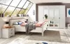 A bedroom scene with a bed, nightstand, and wardrobe. Podgląd zdjęcia produktu