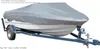A boat covered with a gray tarp is on a blue trailer, shown from a side-angle. Produktbild-Vorschau