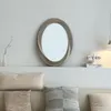 A decorative mirror is mounted on a wall above a shelf with pillows on a sofa below. Anteprima dell’immagine prodotto