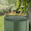 A green rain barrel filled with water in a garden setting, with a downspout feeding water into it. Náhled obrázku produktu