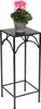 A black metal plant stand with a potted pink cyclamen plant on top. Anteprima dell’immagine prodotto