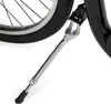 A close-up view of a bicycle kickstand attached to the frame near the rear wheel. Voir les images du produit