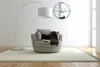 A modern living room scene with a floor lamp, armchair, and a wall clock. Náhled obrázku produktu