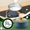 A pot of milk being heated on a stove, with a close-up of another pot in the foreground. Voir les images du produit