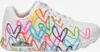 A side view of a white SKECHERS sneaker with a colorful heart print. Voir les images du produit