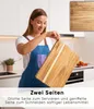 A woman in a kitchen holding a wooden cutting board. Náhled obrázku produktu