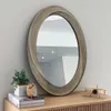 A mirror is displayed on a wooden dresser with decorative items. Anteprima dell’immagine prodotto