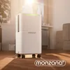 A white dehumidifier with a green LED light on top is placed on a wooden floor in a room with soft lighting. Produktbild-Vorschau