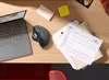 A desk with a laptop, mouse, papers, and office supplies. Anteprima dell’immagine prodotto