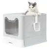 A cat is sitting on top of a gray and white litter box. Náhled obrázku produktu