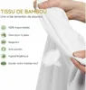 A hand is holding and demonstrating a white fabric, likely a mattress protector, with text overlays describing its features. Produktbild-Vorschau