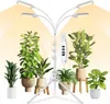 A white LED grow light stand with multiple adjustable arms and lights, surrounded by several potted houseplants of various sizes and types. Produktbild-Vorschau