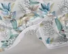 A close-up view of a white bedding set with a floral pattern of lily of the valley and leaves. The zipper of the duvet cover is partially open, revealing the inside. Produktbild-Vorschau