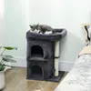 A cat is sleeping on a dark gray cat tree next to a bed. Produktbild-Vorschau
