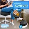 A person is sitting on a black rolling stool and reading a book. The image highlights features of the stool. Produktbild-Vorschau