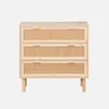A light wood dresser with three rattan-fronted drawers and wooden legs, set against a plain light gray background. Produktbild-Vorschau