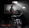 A smartphone gimbal stabilizer with a phone attached, showing a person on the phone's screen. A fill light is attached to the phone. Produktbild-Vorschau