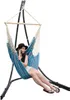 A woman is sitting in a hanging chair and talking on her phone. Anteprima dell’immagine prodotto