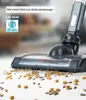 A close-up of a cordless vacuum cleaner head on the floor, with scattered debris like corn kernels and seeds. Produktbild-Vorschau