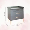 A gray dresser with three drawers and wooden legs, with dimensions indicated. Produktbild-Vorschau