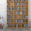 A wooden bookshelf filled with CDs, next to an electric guitar. Náhled obrázku produktu