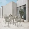 An outdoor patio setting with a dining set and a potted plant. Voir les images du produit
