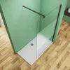 A modern shower enclosure with a glass panel and black frame, set against a green wall and wooden floor. Produktbild-Vorschau